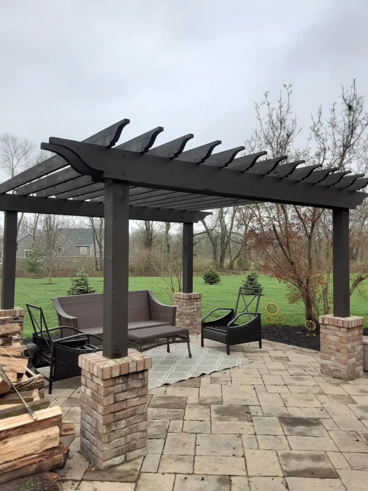Pergola stained dark over a paver patio