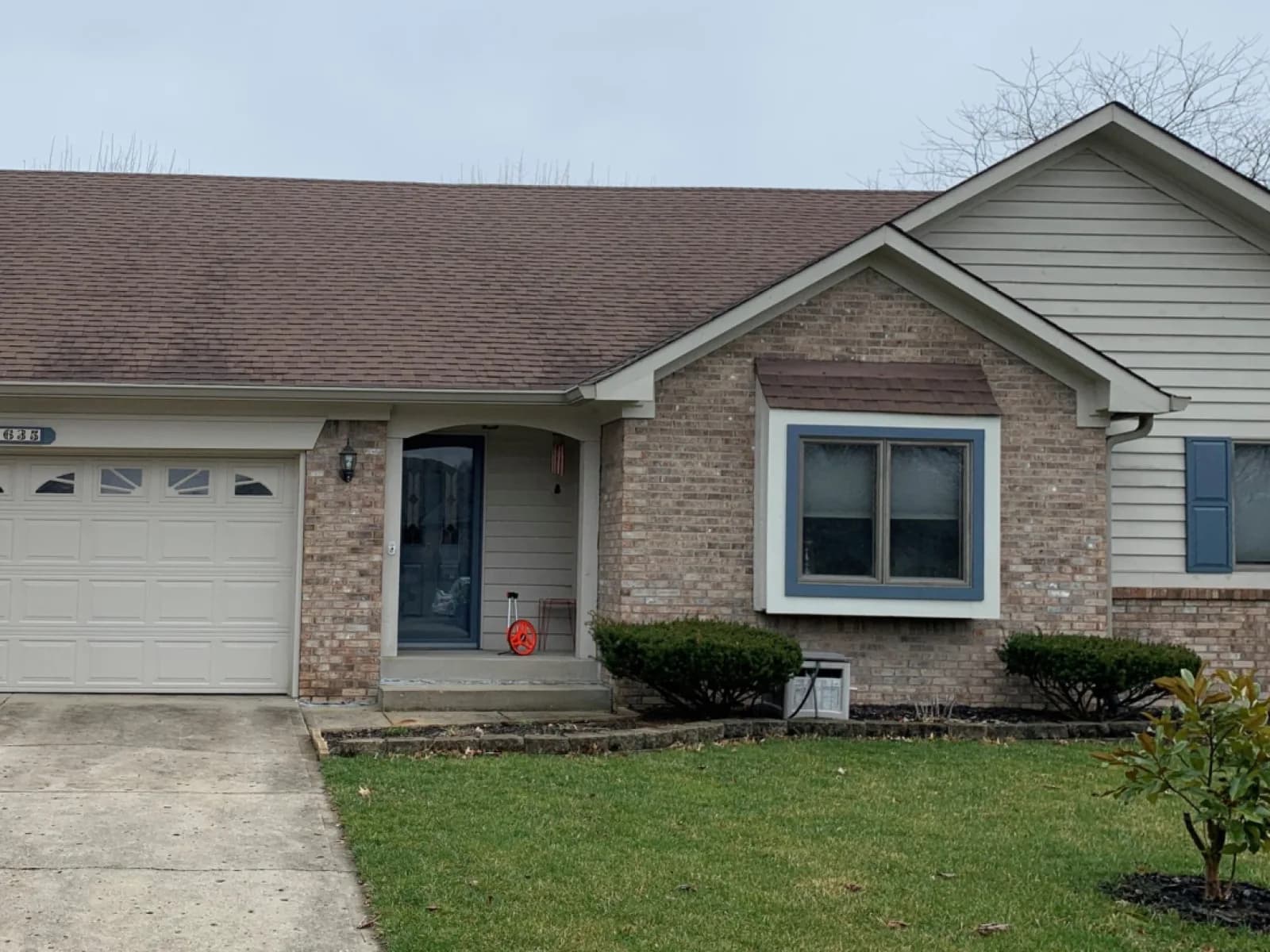 Before: Ranch siding and shutters repainted, brick left alone