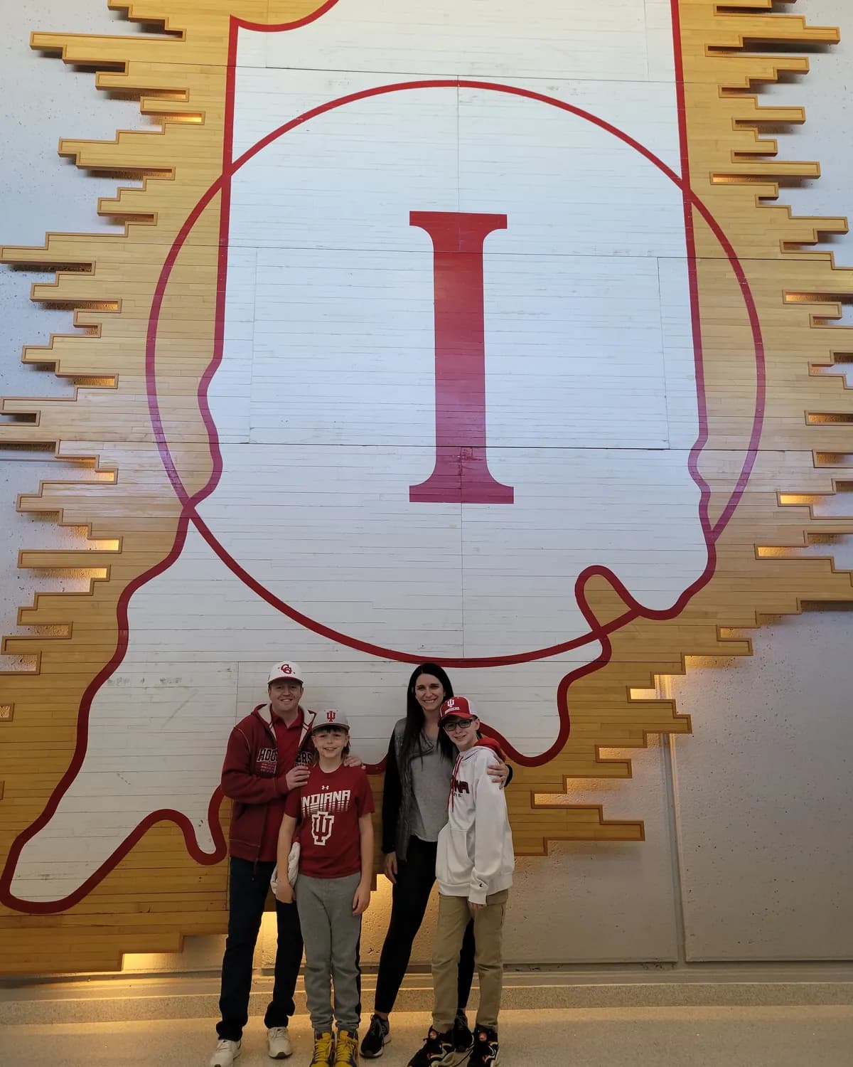 Luke, our owner, with his family in IU gear under a giant IU logo on an Indiana-shaped wall