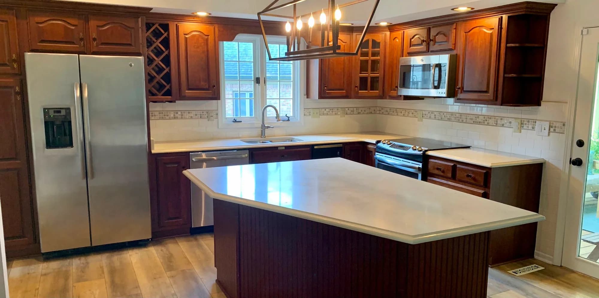 Before: Cherry kitchen cabinets painted white, island included